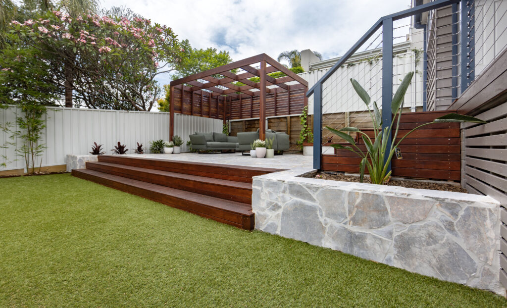 Landscape design and construct project in New Lambton completed with a timber pergola, crazy pave, synthetic turf, and an outdoor entertainment area.