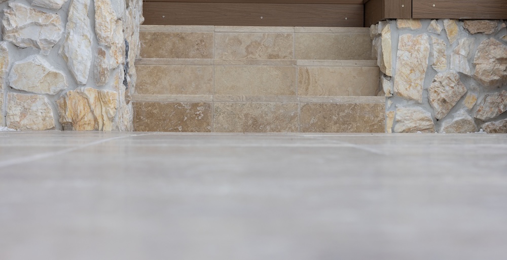 Pool surrounds landscaping in Cameron Park with pergola, decking, and travertine pavers. 