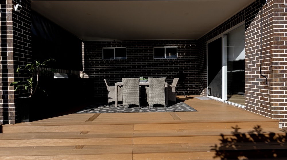 Pool surrounds landscaping in Cameron Park with pergola, decking, and travertine pavers. 