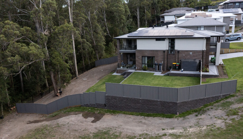 Newcastle landscaping project with excavation, retaining walls, drainage, turfing, planting, paving, and gardens.