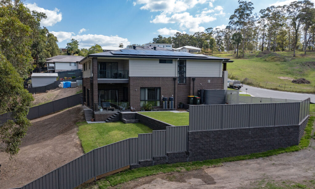 Fletcher landscaping project. Full backyard transformation in Newcastle with retaining walls, drainage, turfing, planting, pavers.