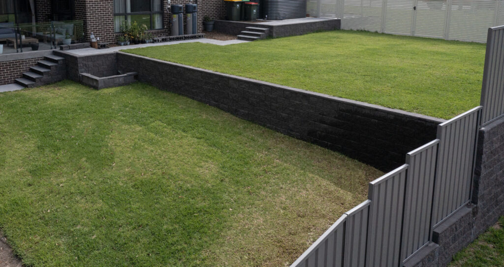 Newcastle landscaping project with excavation, retaining walls, drainage, turfing, planting, paving, and gardens.