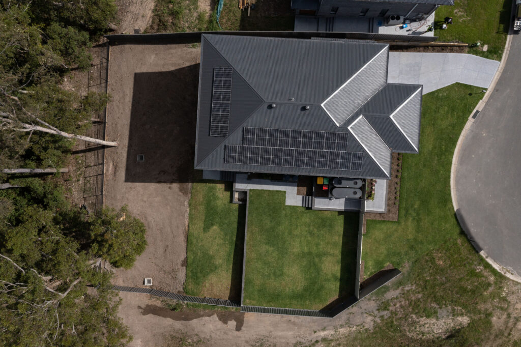 Newcastle landscaping project with excavation, retaining walls, drainage, turfing, planting, paving, and gardens.