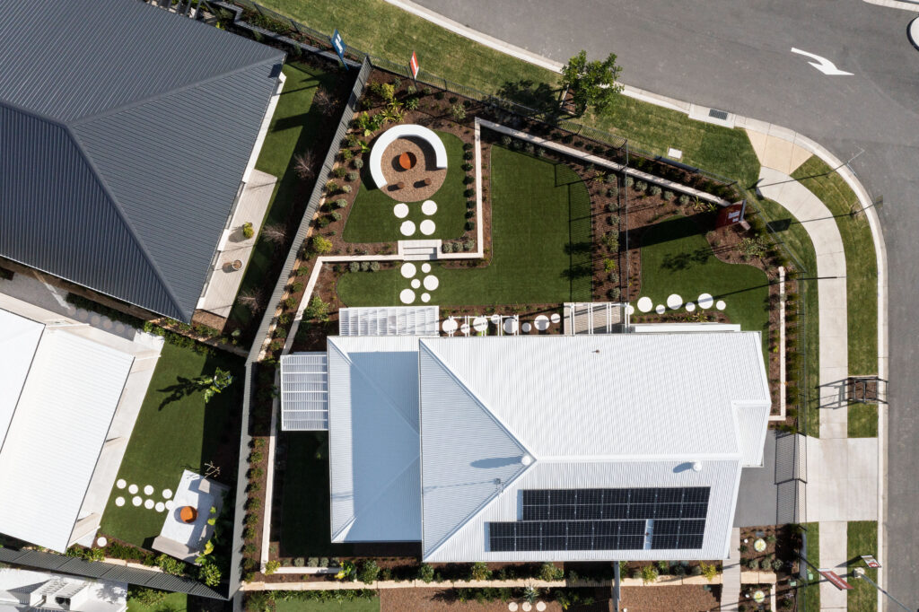 Commercial Domaine display home project in Cooranbong NSW consisting of decorative screening, turfing, retaining walls, steppers, fire pit space, concrete seating, planting and a pergola.