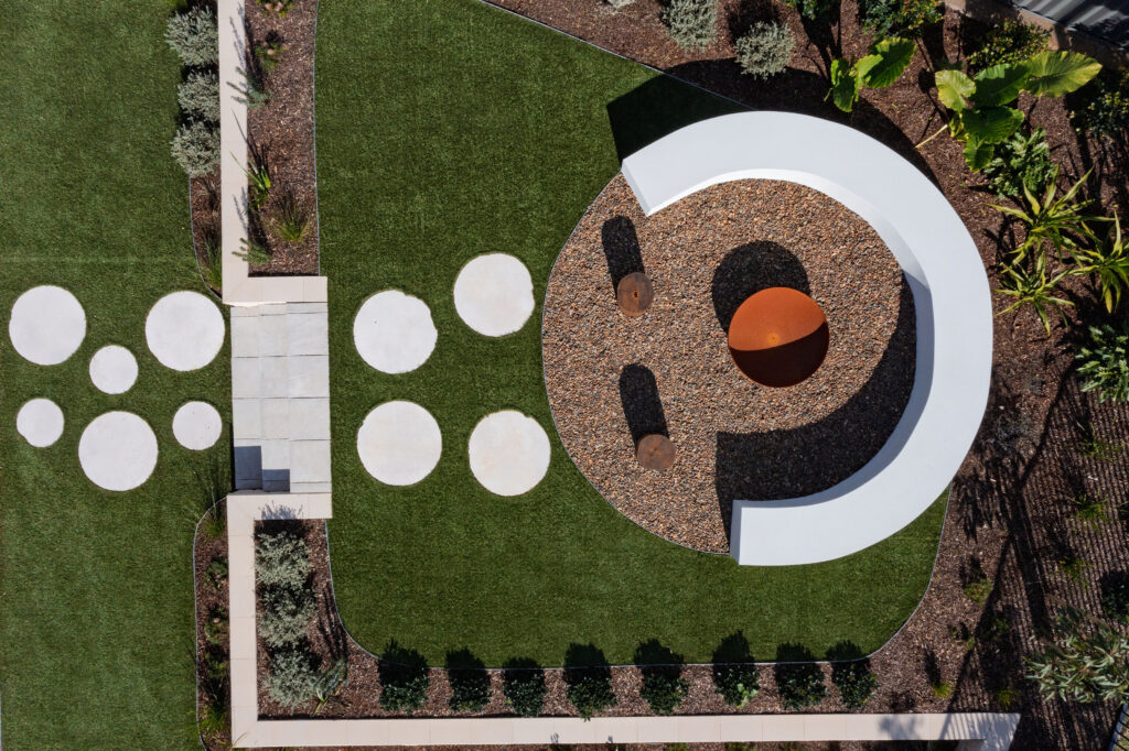 Commercial Domaine display home project in Cooranbong NSW consisting of decorative screening, turfing, retaining walls, steppers, fire pit space, concrete seating, planting and a pergola.