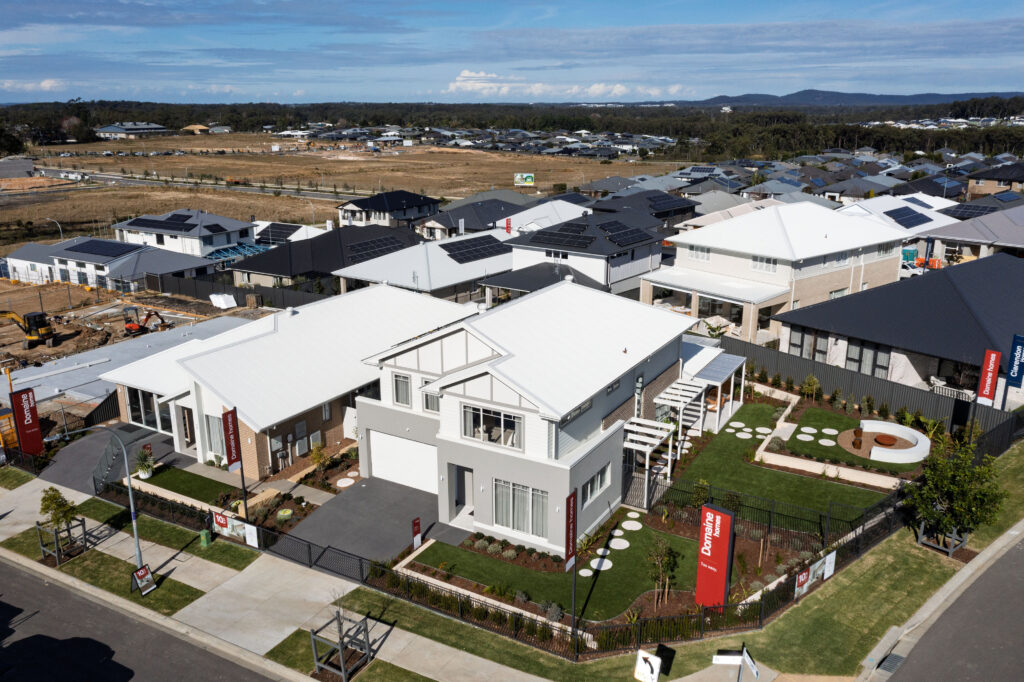 Commercial Domaine display home project in Cooranbong NSW consisting of decorative screening, turfing, retaining walls, steppers, fire pit space, concrete seating, planting and a pergola.