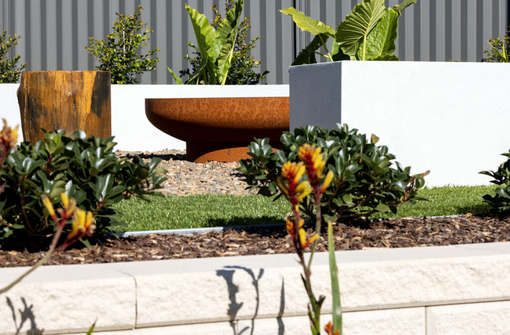 Commercial Domaine display home project in Cooranbong NSW consisting of decorative screening, turfing, retaining walls, steppers, fire pit space, concrete seating, planting and a pergola.