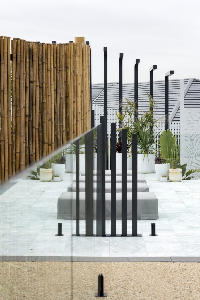 Completed pool surrounds landscaping project in Louth Park, including pool surround paving, decorative screening, glass pool fencing, and planting. 