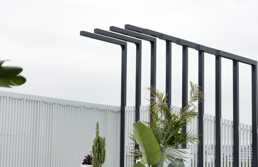 Completed pool surrounds landscaping project in Louth Park, including pool surround paving, decorative screening, glass pool fencing, and planting. 