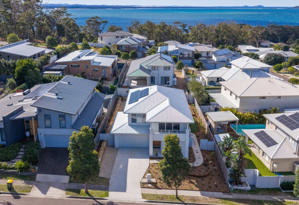 Aerial view of native garden design Corlette home with coastal views beyond