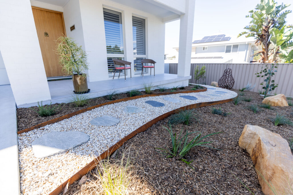 Native garden design Corlette front pathway with corten steel edging and garden sculpture