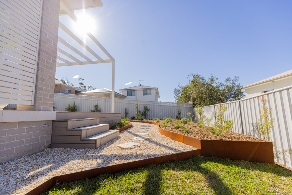 Tiered garden steps and native planting along the rear fence line, Corlette landscape design