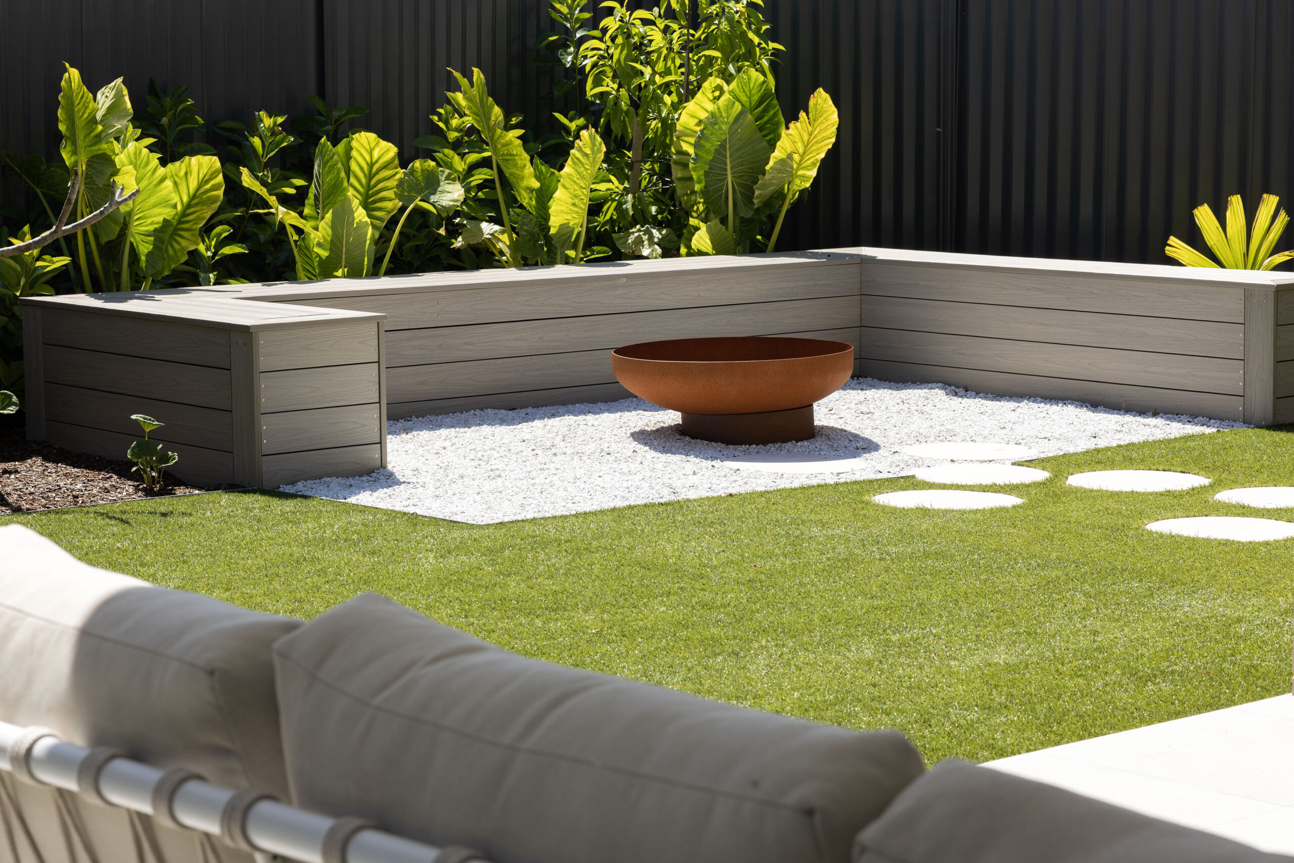 Firepit and bench seating in the display home backyard landscaping at Cooranbong