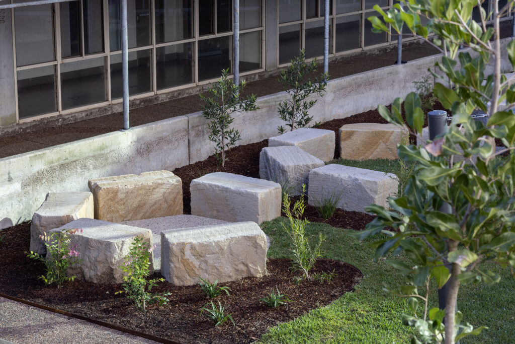 Completed yarning circle and sandstone seating at John Hunter Hospital, with hospital building behind