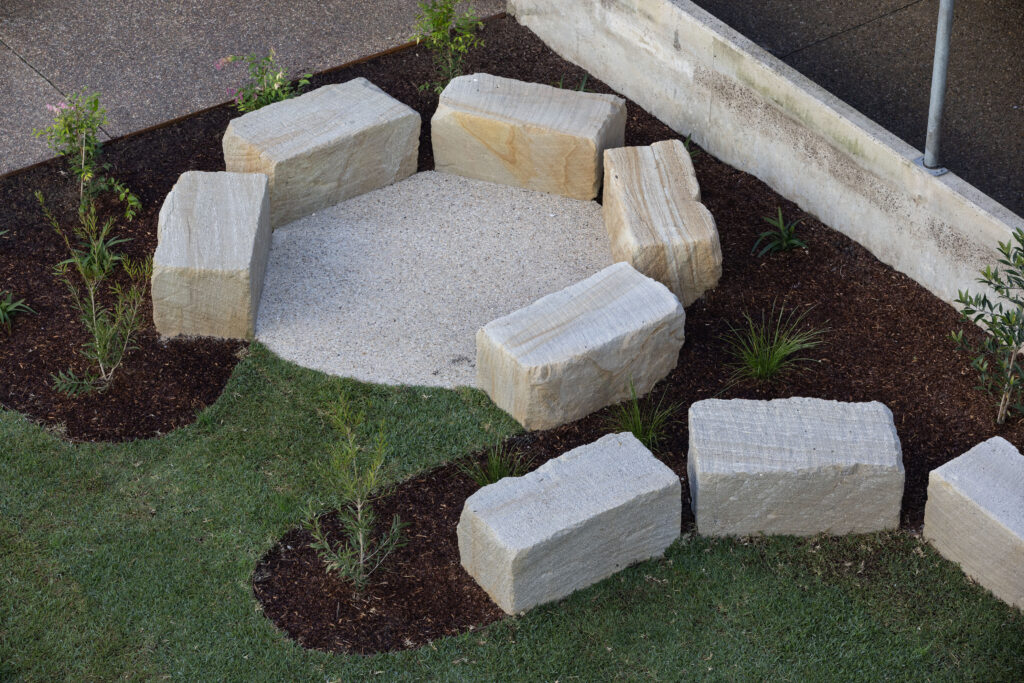 Aerial view of the yarning circle at John Hunter Hospital, showing sandstone seating around the exposed aggregate pad