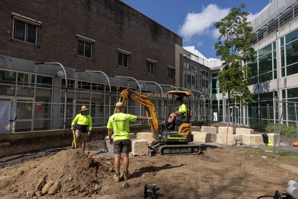 Construction of the yarning circle at John Hunter Hospital, with sandstone logs being arranged on site