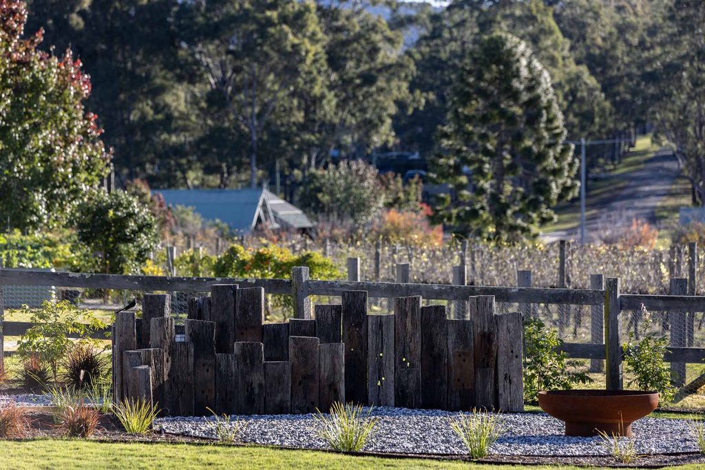 Fire pit with Corten steel edging and railway sleeper screen backing onto a Hunter Valley vineyard in Pokolbin