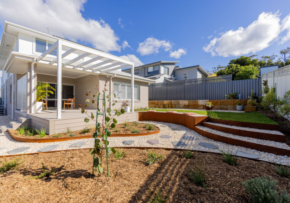 Native garden design Corlette rear yard with pergola, deck and sandstone retaining wall