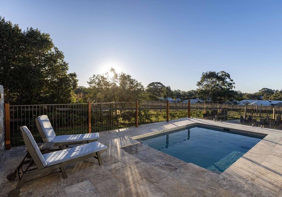 Finished pool landscaping Pokolbin project with frameless glass fencing framing an uninterrupted vineyard view
