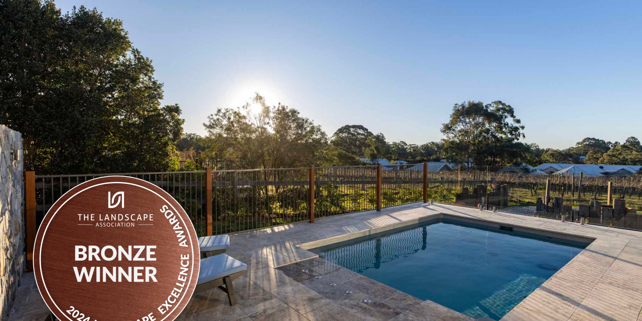 Finished pool landscaping Pokolbin project with frameless glass fencing framing an uninterrupted vineyard view
